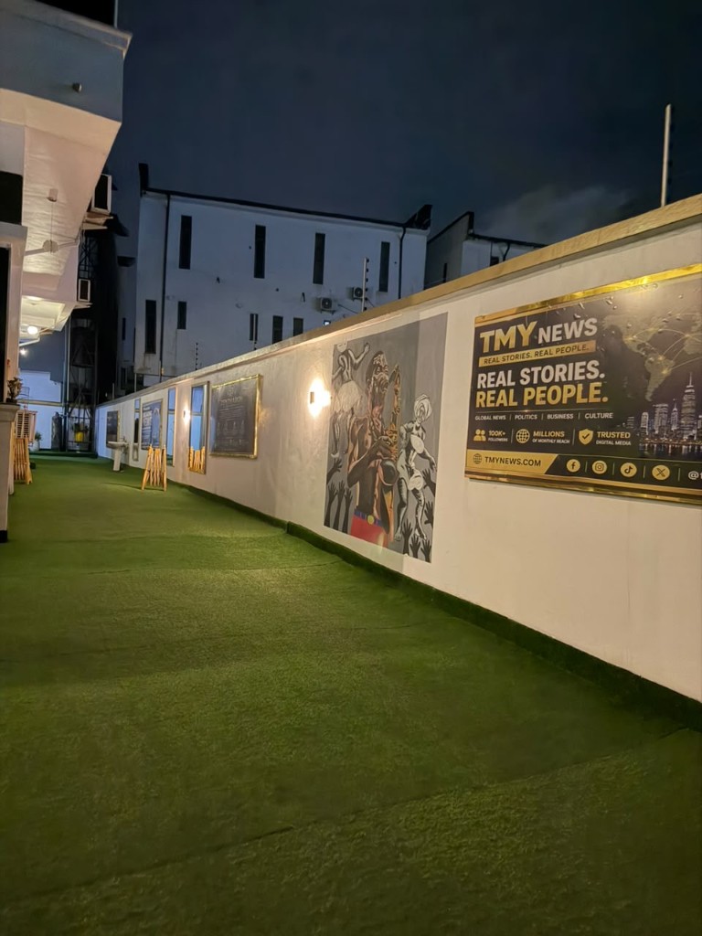 TMY News billboard on the yard wall: Real stories. Real people.