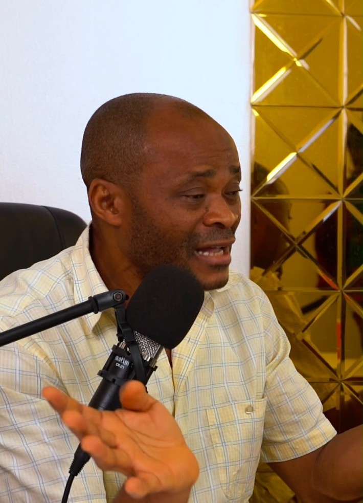 A host at the microphone in a patterned top.